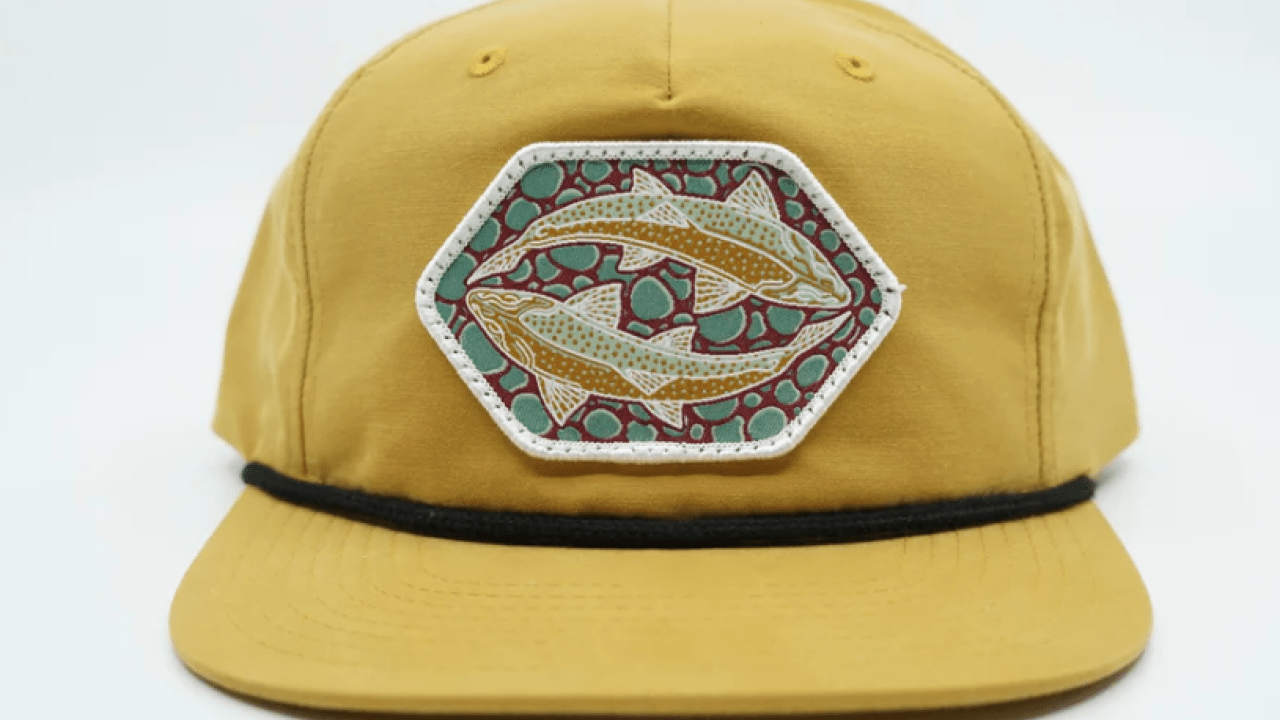 Yellow hat with fish patch on it.